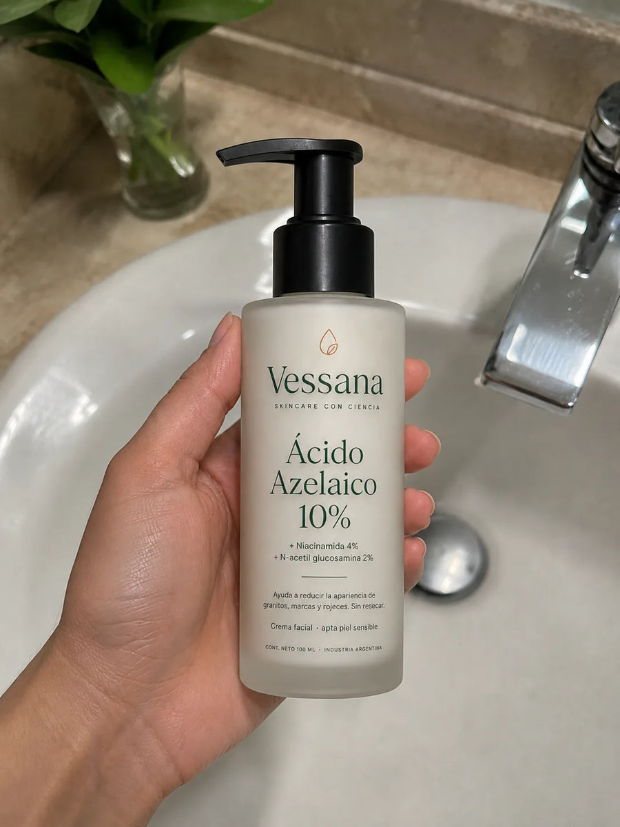 Mano sosteniendo el frasco de Vessana de 100 ml sobre la bacha del baño